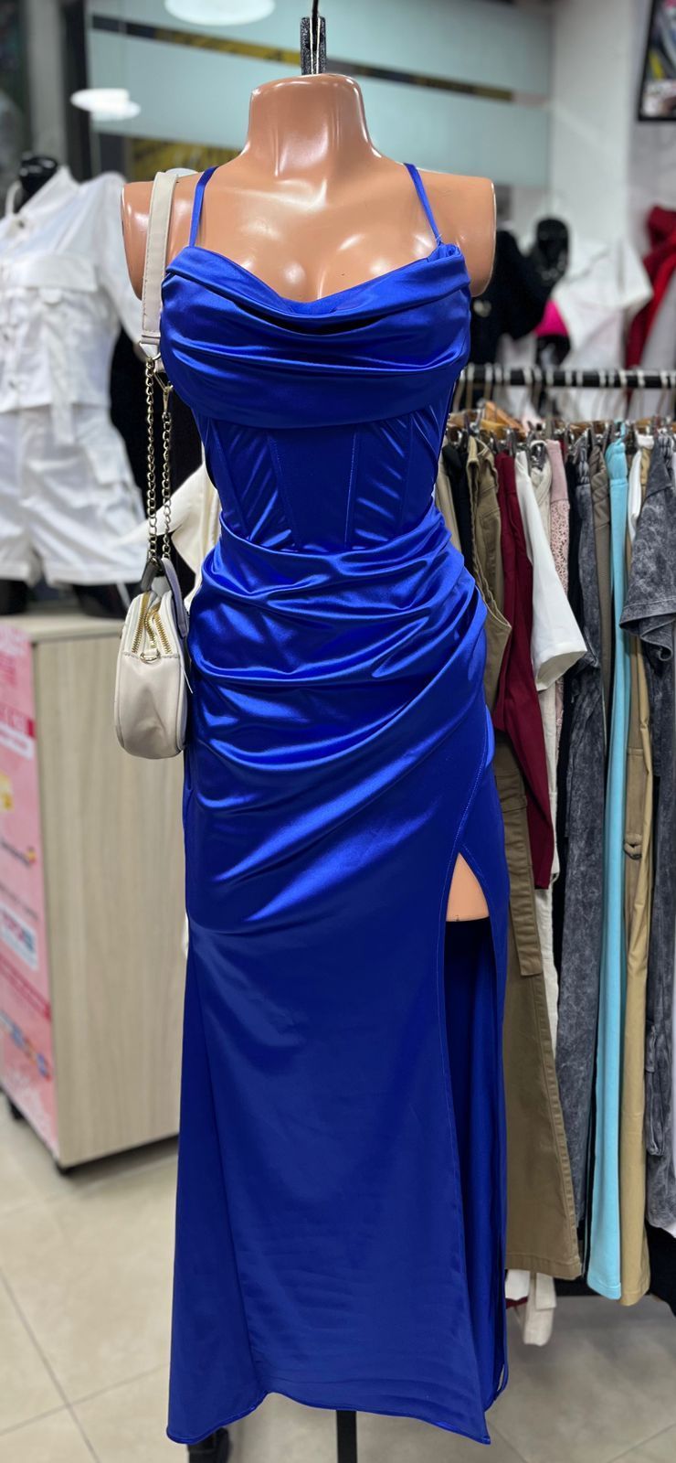 Un vestido de satén azul marino sobre un maniquí con tirantes finos y una abertura en el muslo.