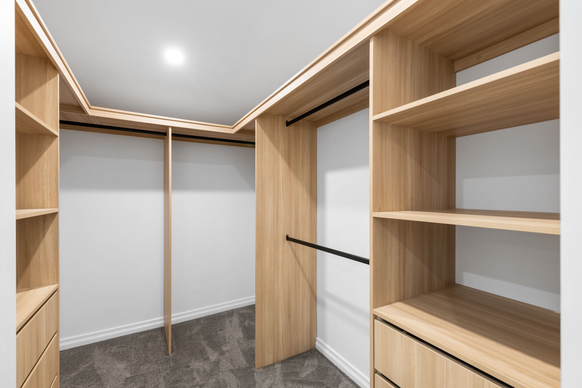 A Walk-in Closet Interior With Light Wood Shelving — Foreshore Kitchens in Mooloolaba, QLD