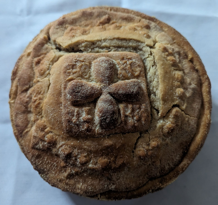 A pie with a cross on it is sitting on a table