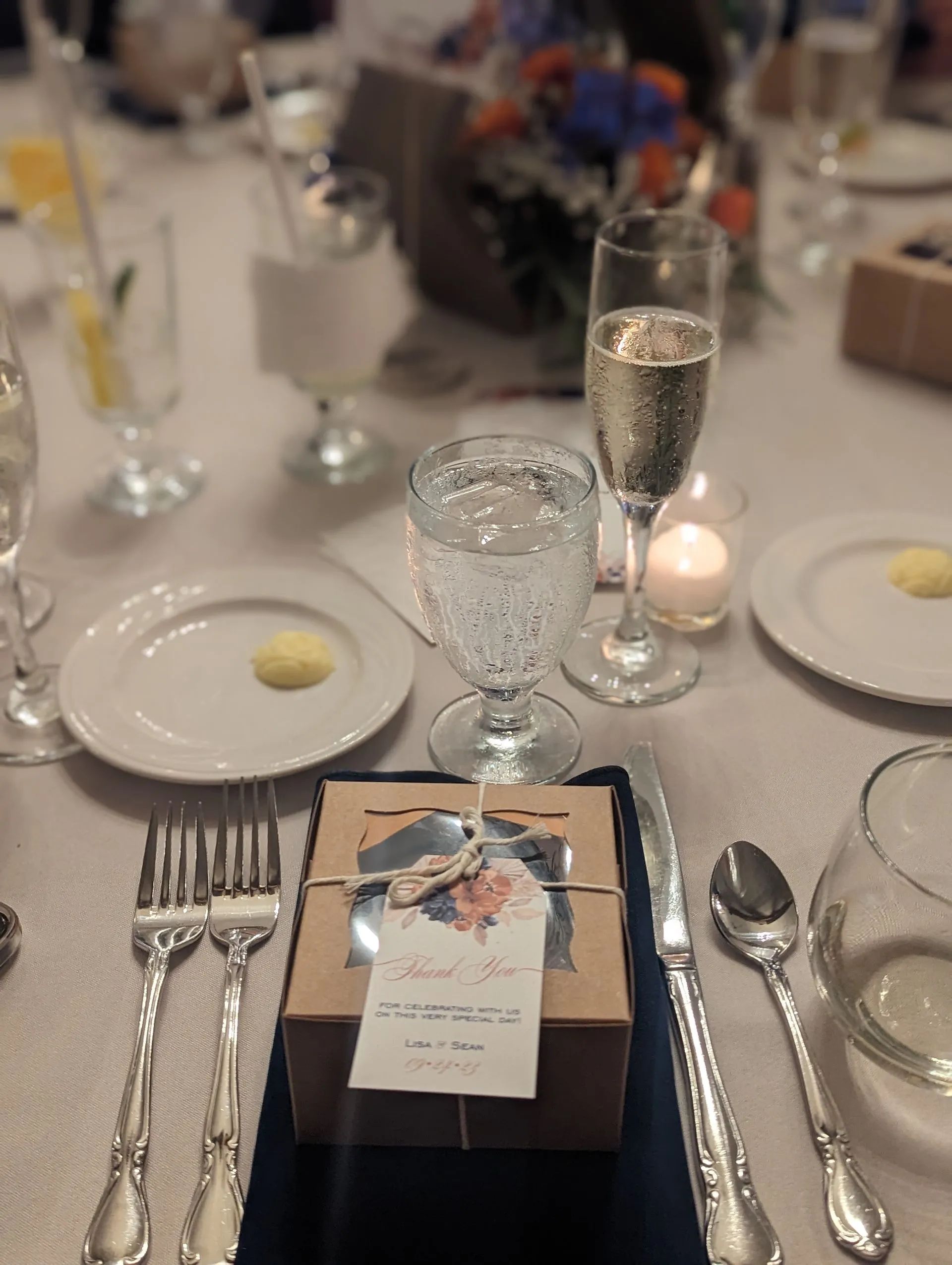 A table setting with a box on it that says thank you