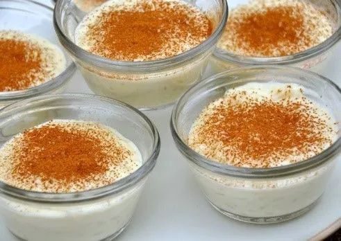Four bowls of dessert with cinnamon on top on a white plate.