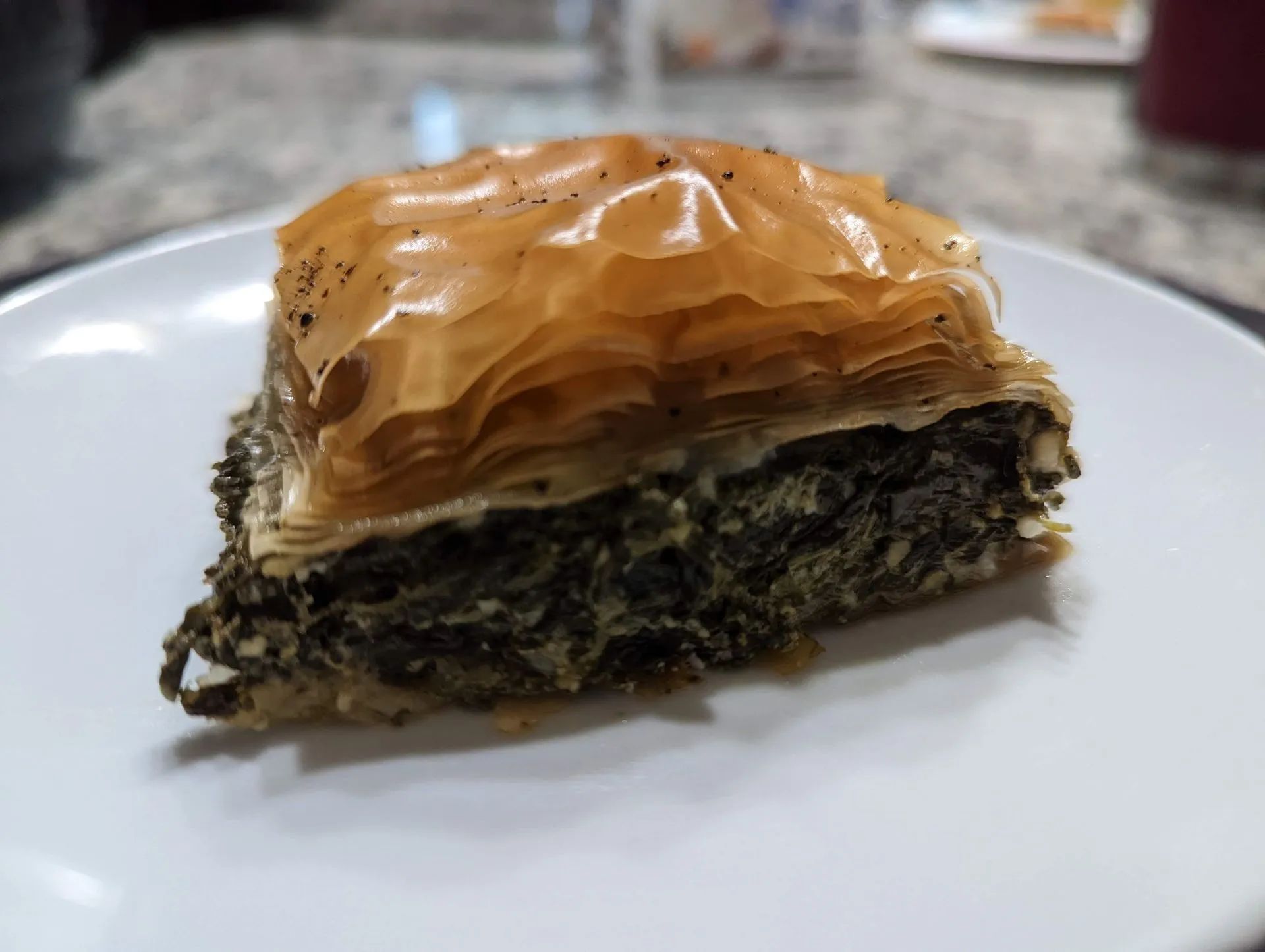 A slice of baklava is on a white plate