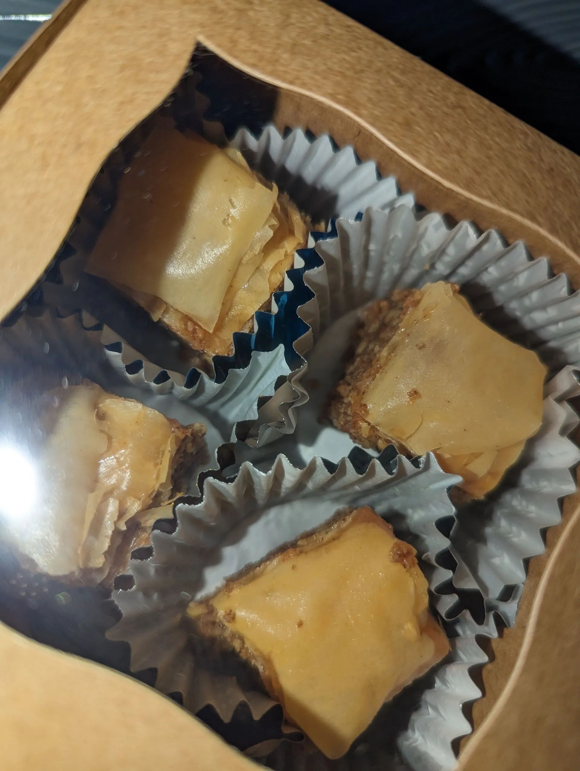 A close up of a box of brownies in cupcake liners