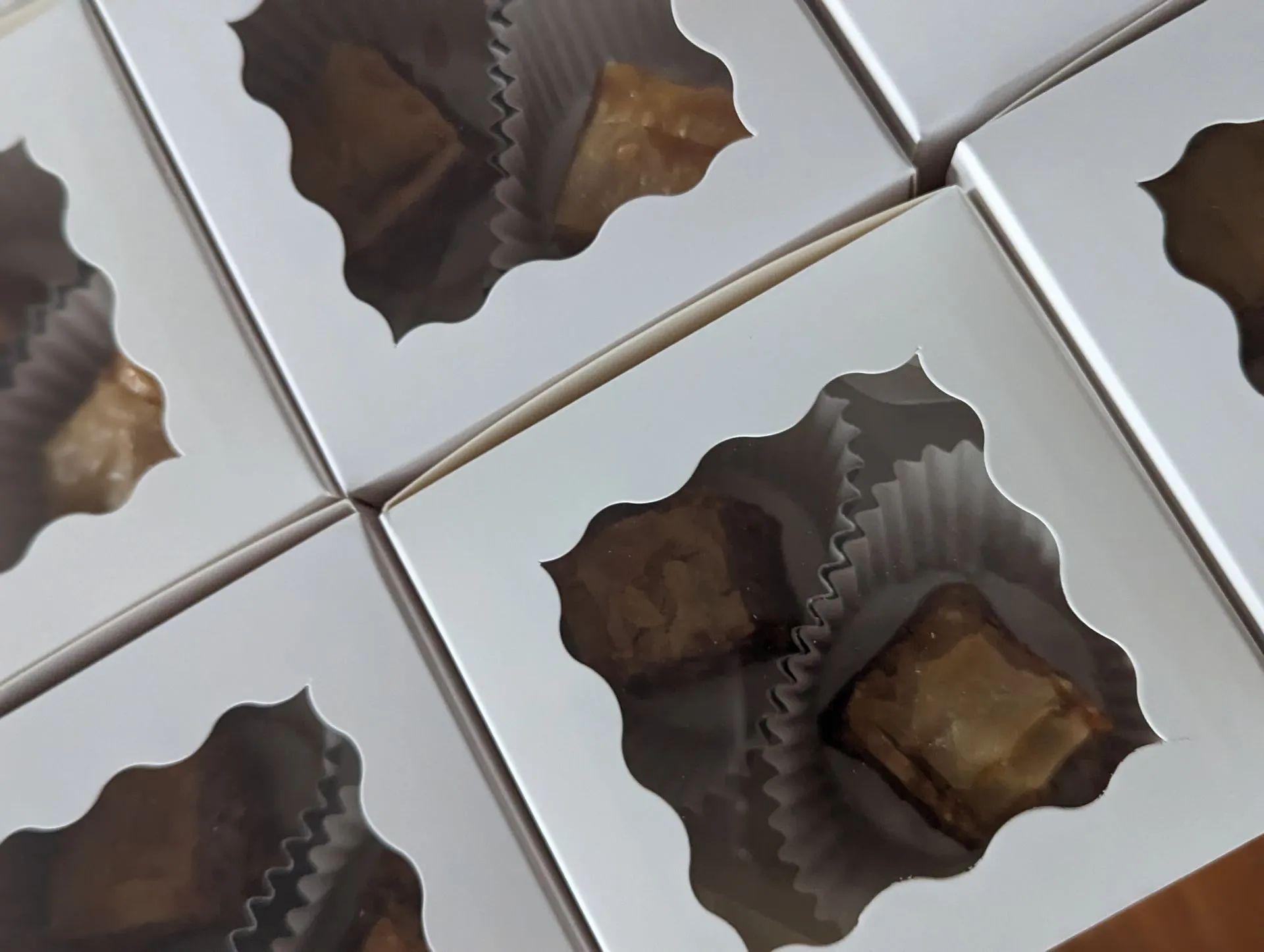 A bunch of white boxes with cupcakes in them