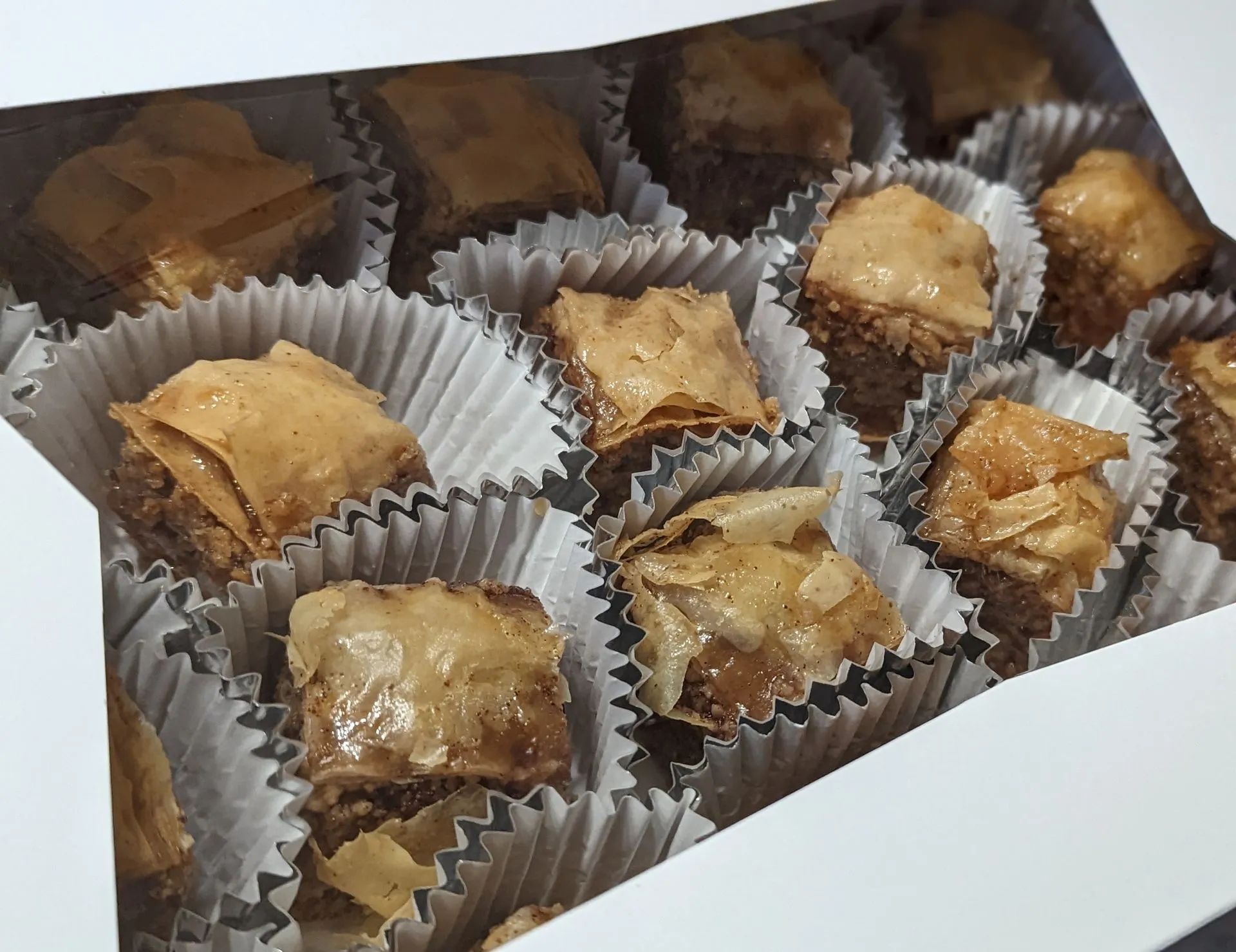 A box filled with baklava in cupcake liners