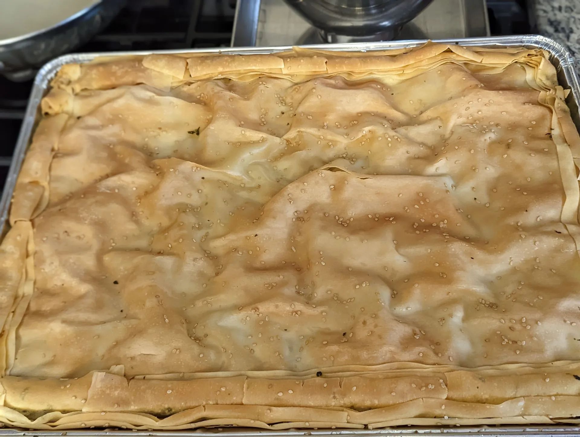 A pie is sitting in a pan on a stove top.