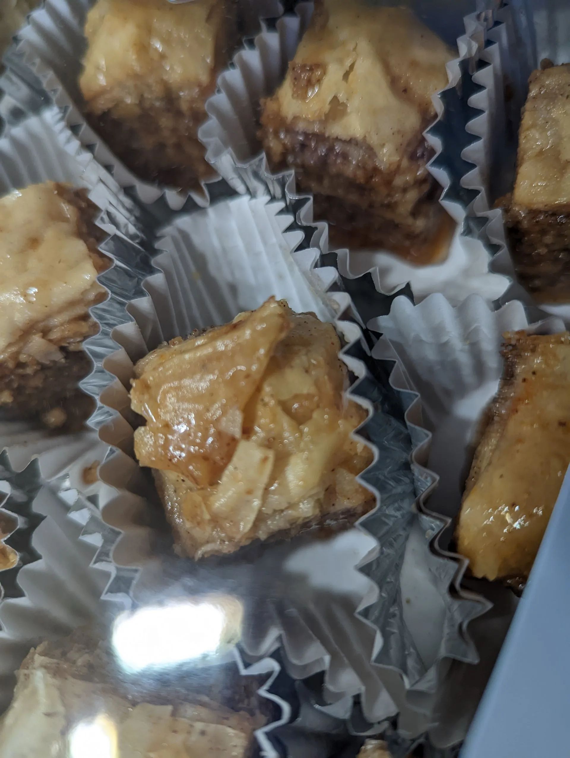 A close up of baklava pieces in cupcake liners