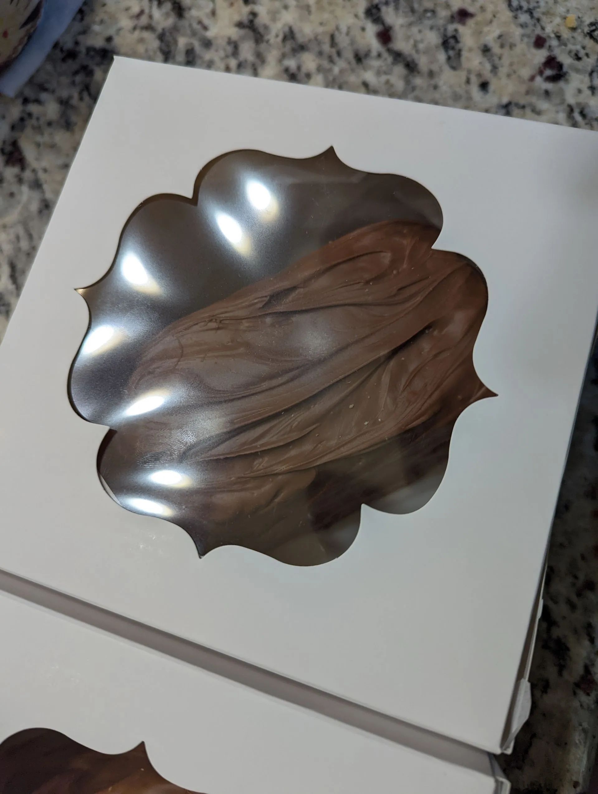 A white box with a cupcake inside of it