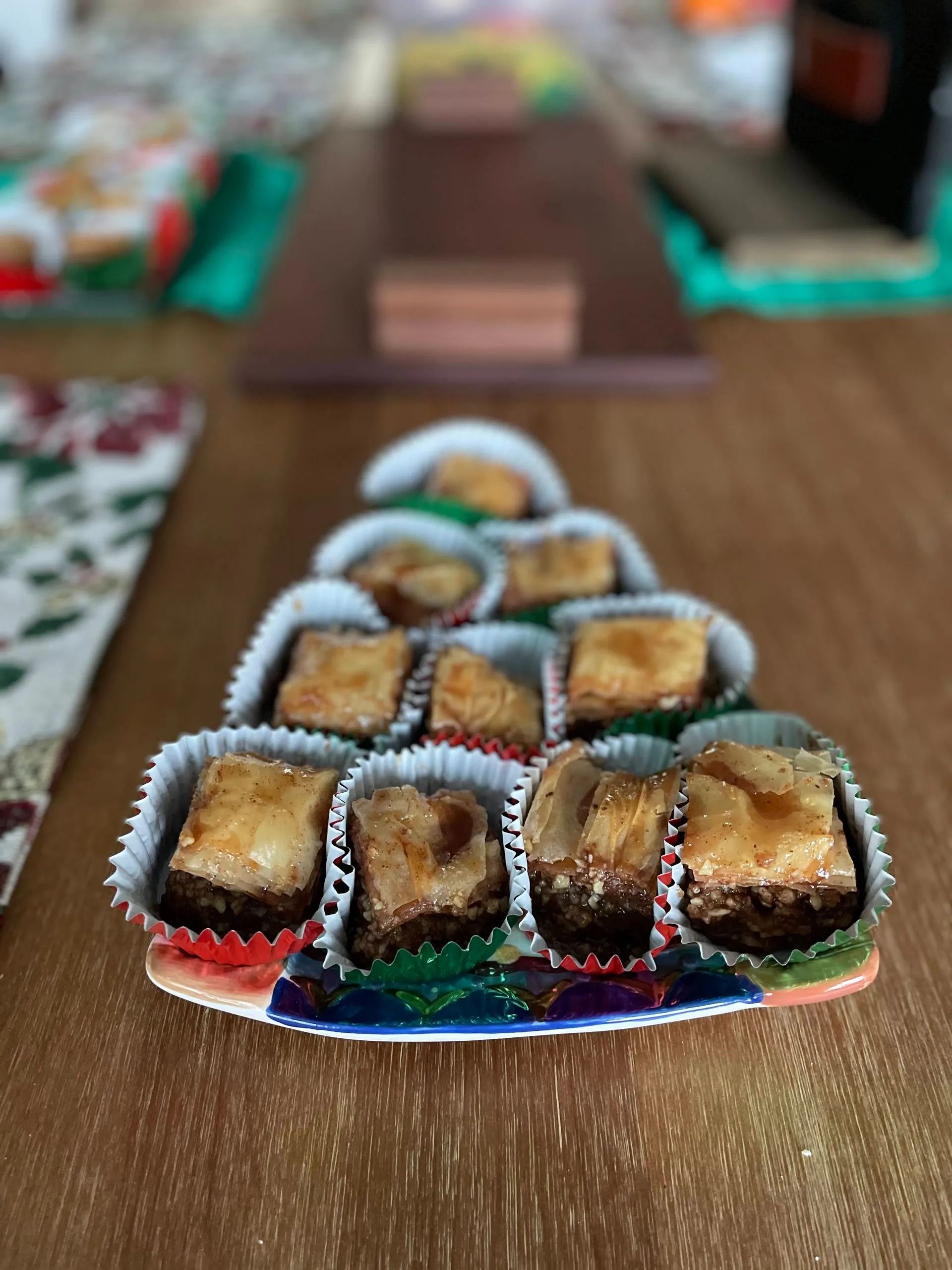 A wooden table topped with cupcakes in the shape of a christmas tree.