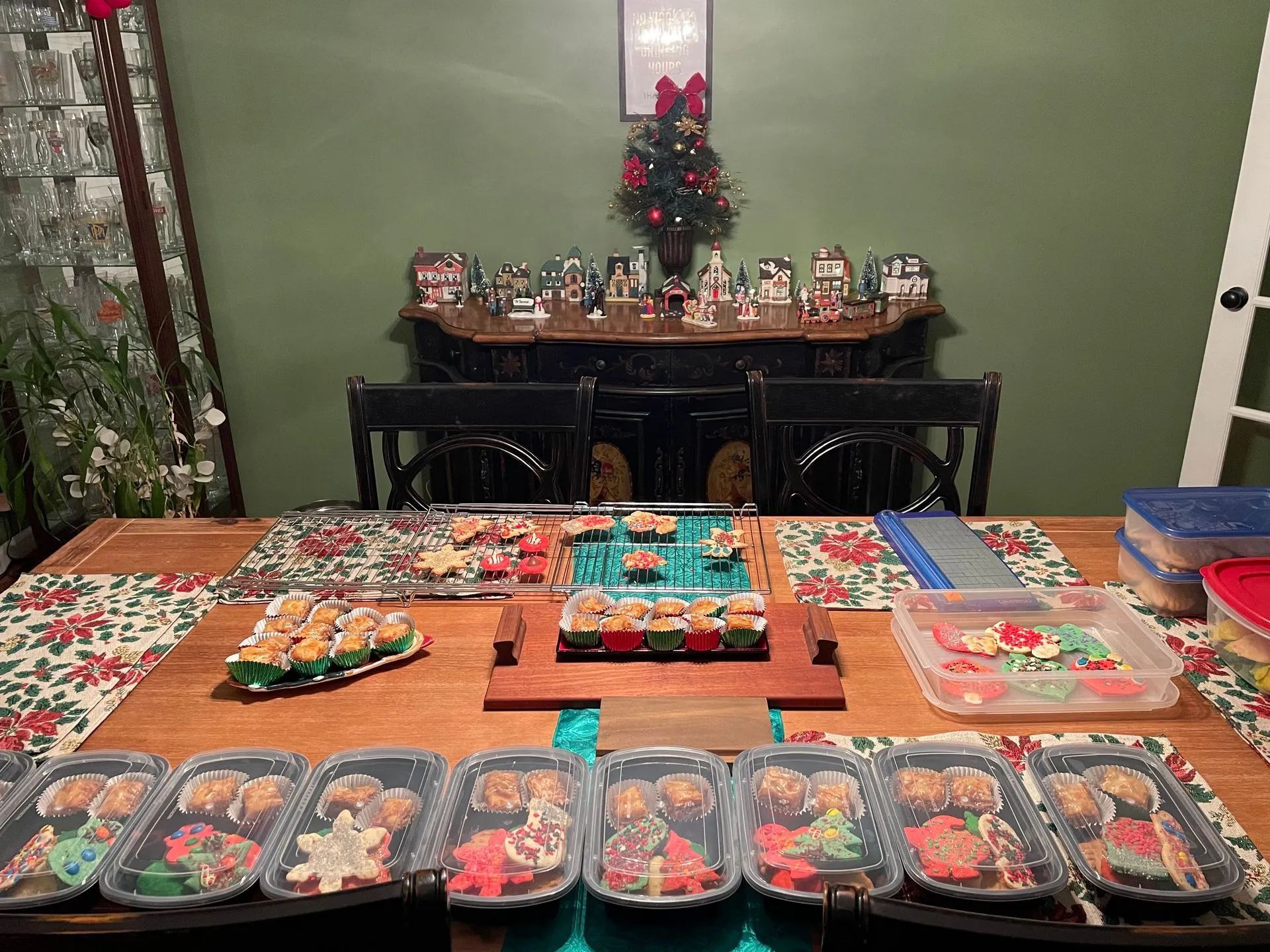 A dining room table with plates of food on it and a christmas tree in the background.