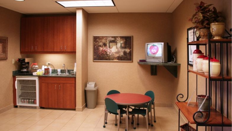 A room with a table and chairs and a television