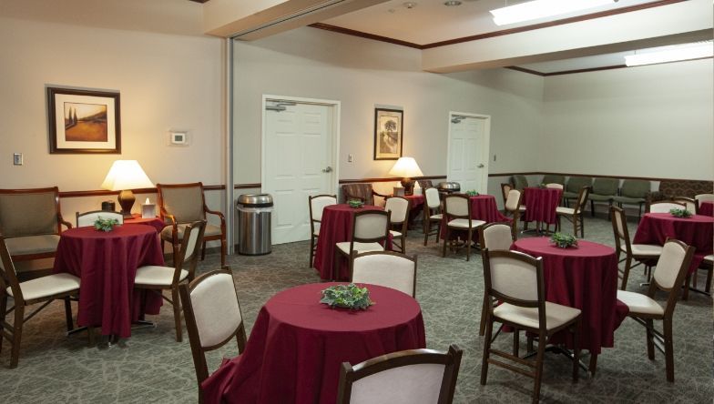 A room with tables and chairs and a trash can