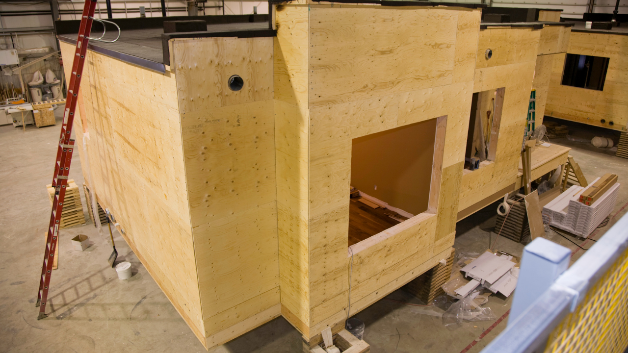Wooden modular building construction; interior view with window openings and ladder.