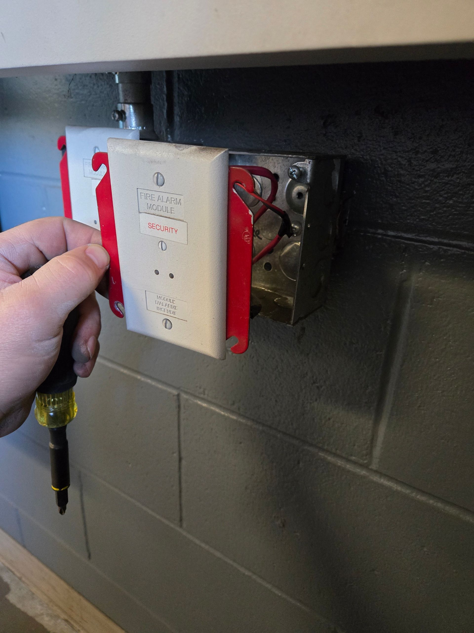 A man installing fire alarm