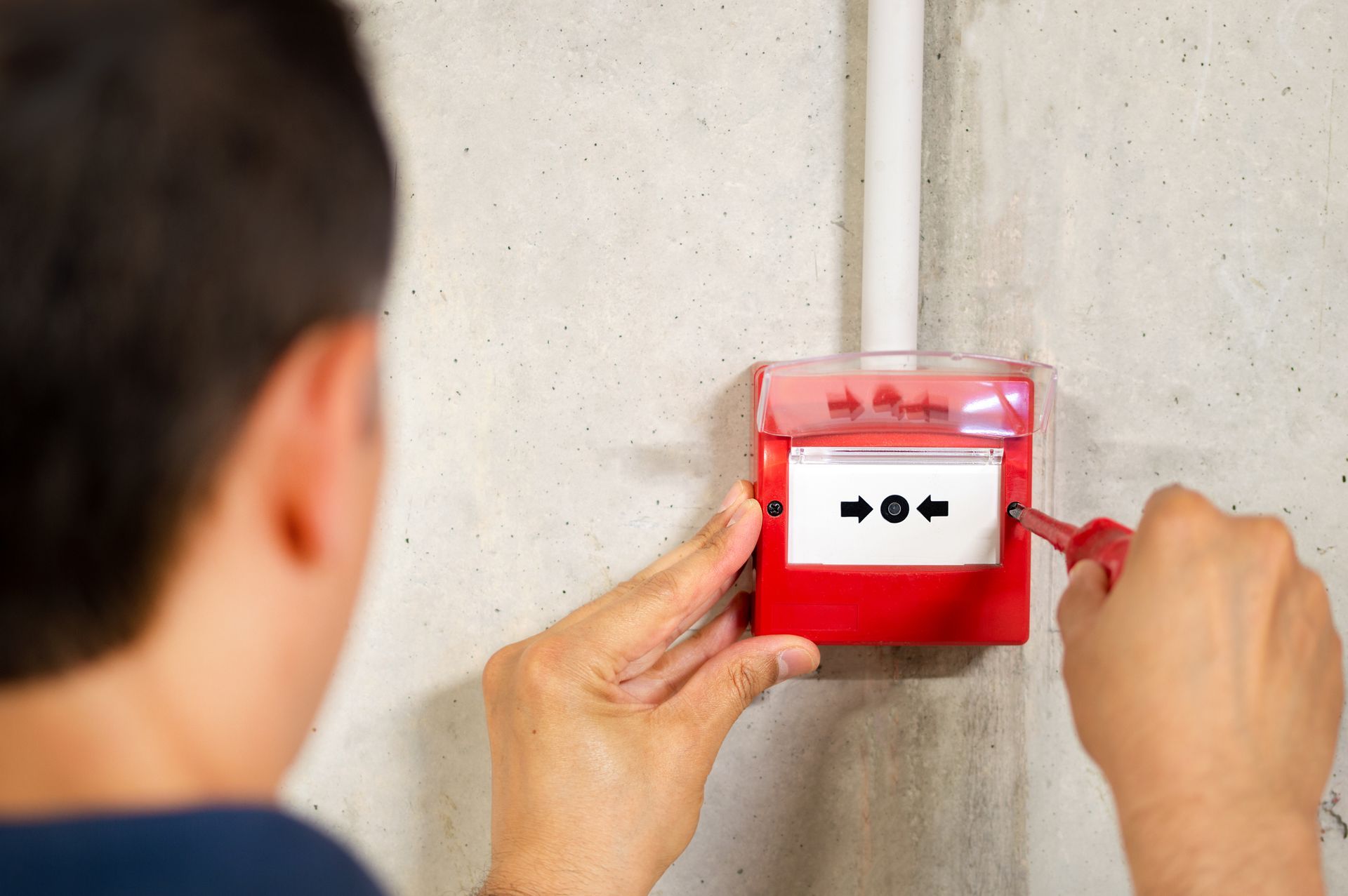 A man installing fire alarm