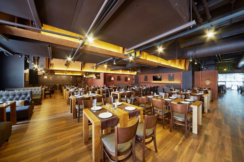 Interior of restaurant with wooden furniture and walls of red bricks