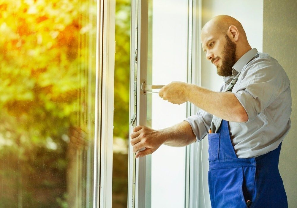 A Man Fixes a Window with A Screwdriver — Envy Glass in Coffs Harbour, NSW