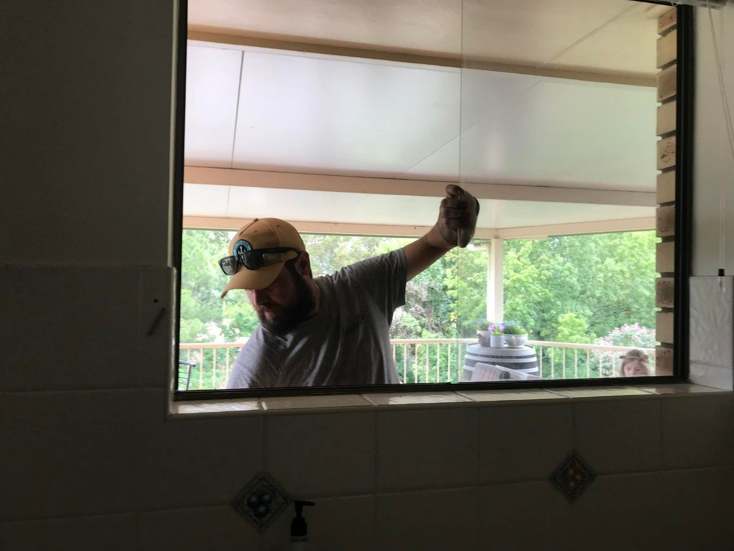 A Man Installing Window from Inside a Room — Envy Glass in Macksville, NSW