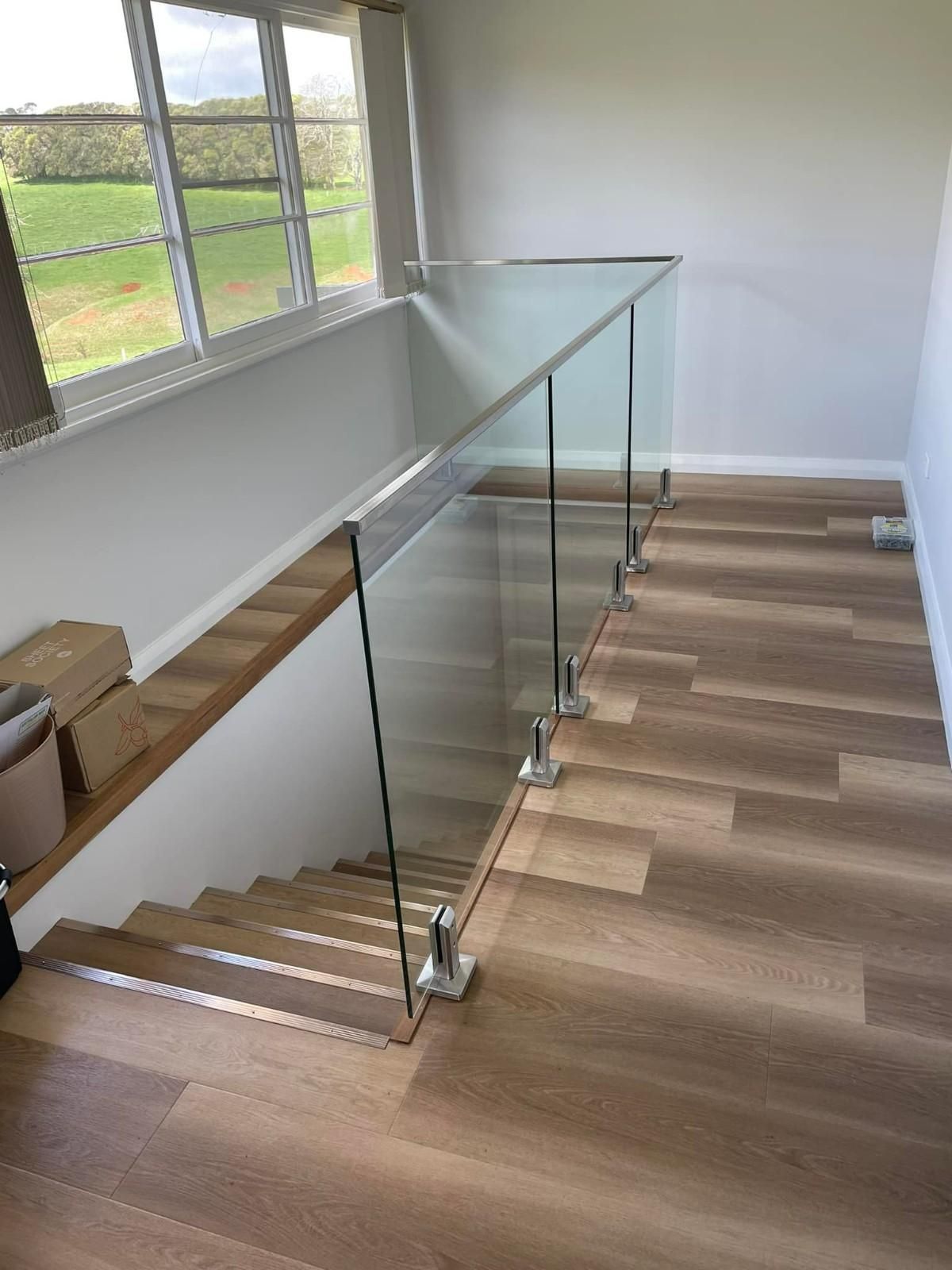 A Glass Railing on A Staircase with Light Wood Floors — Envy Glass in Coffs Harbour, NSW