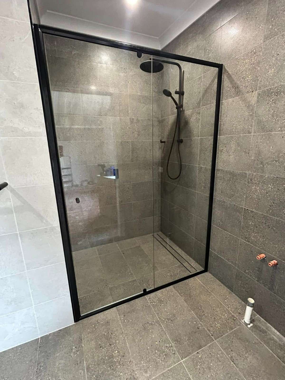 A Framed Glass Shower with Showerhead — Envy Glass in Macksville, NSW