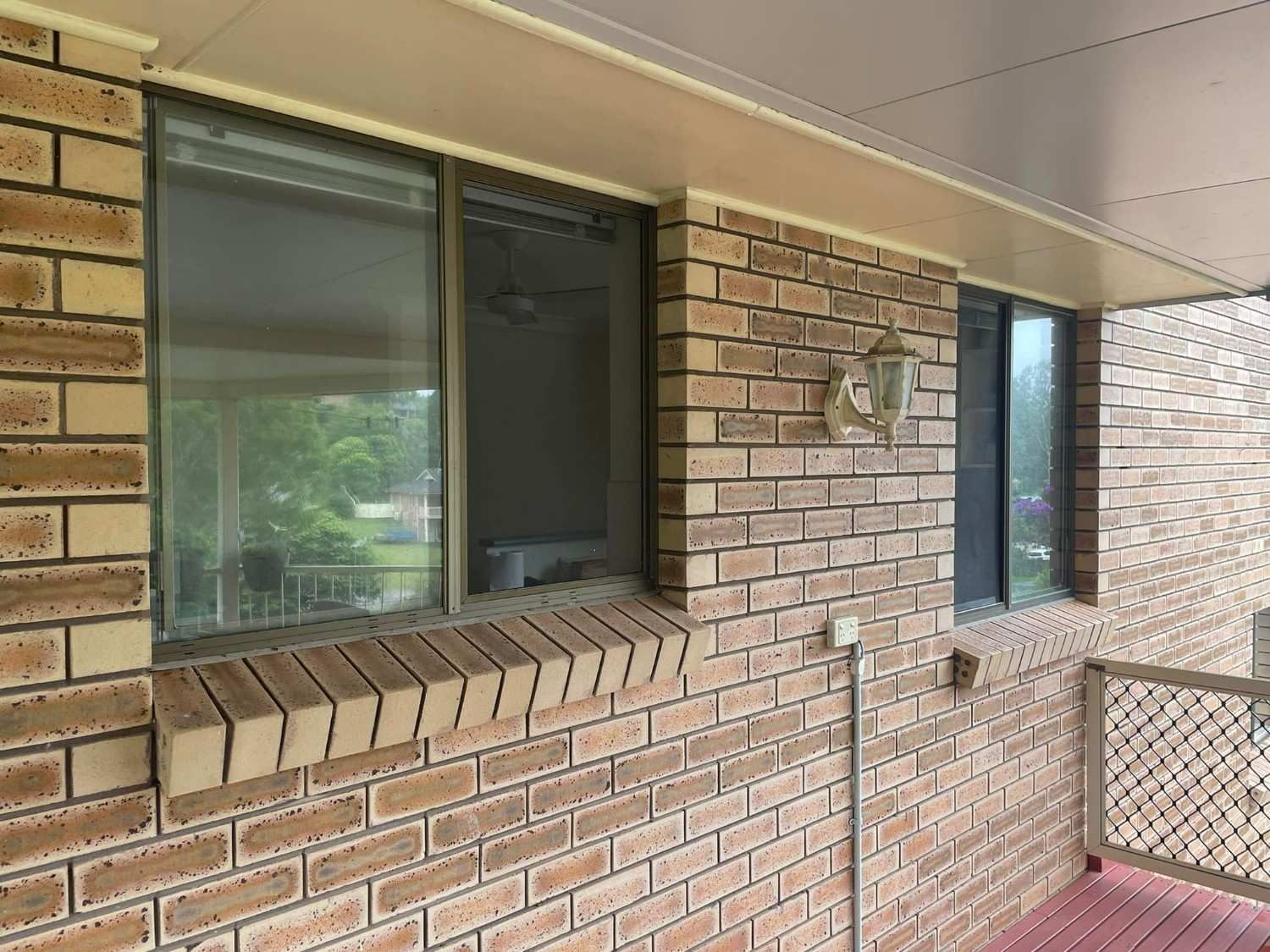 A Brick Exterior Wall with Two Windows — Envy Glass in Coffs Harbour, NSW