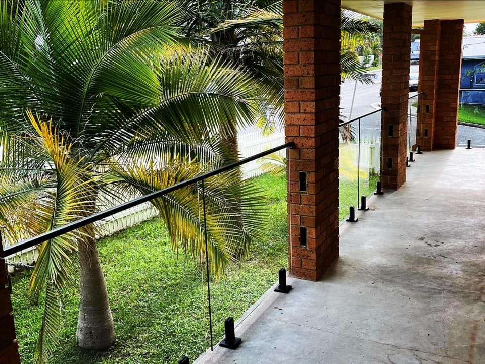 A Balcony with Glass Railing and Brick Columns — Envy Glass in Nambucca Heads, NSW