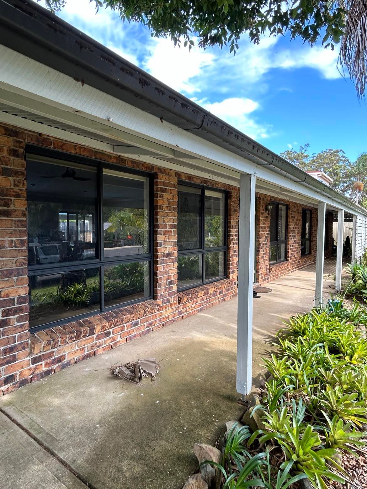 Brick house with large windows under a covered porch — Envy Glass in Nambucca Heads, NSW