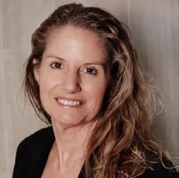 A woman with long hair is smiling for the camera.