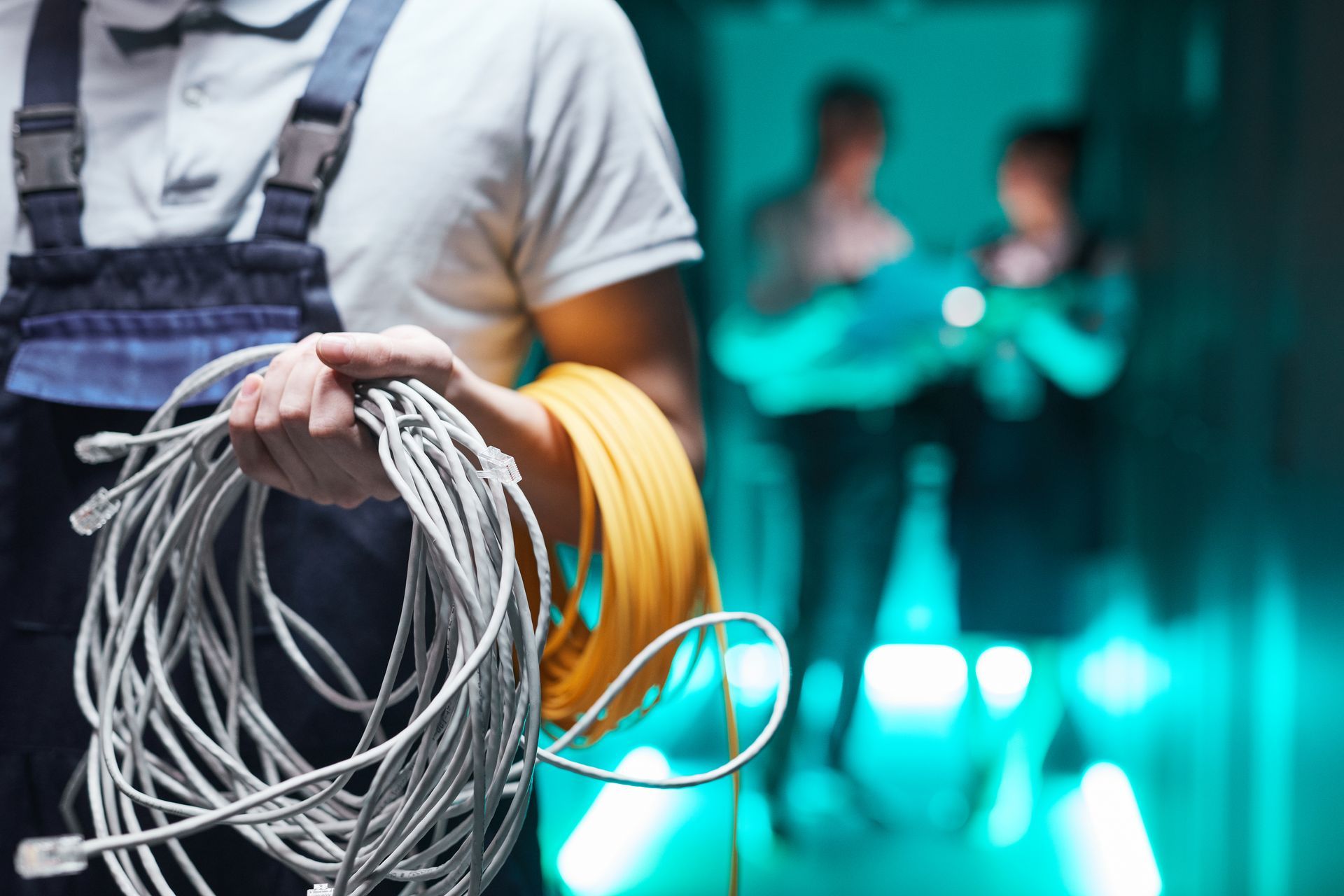 A man is holding a roll of wires in his hands.