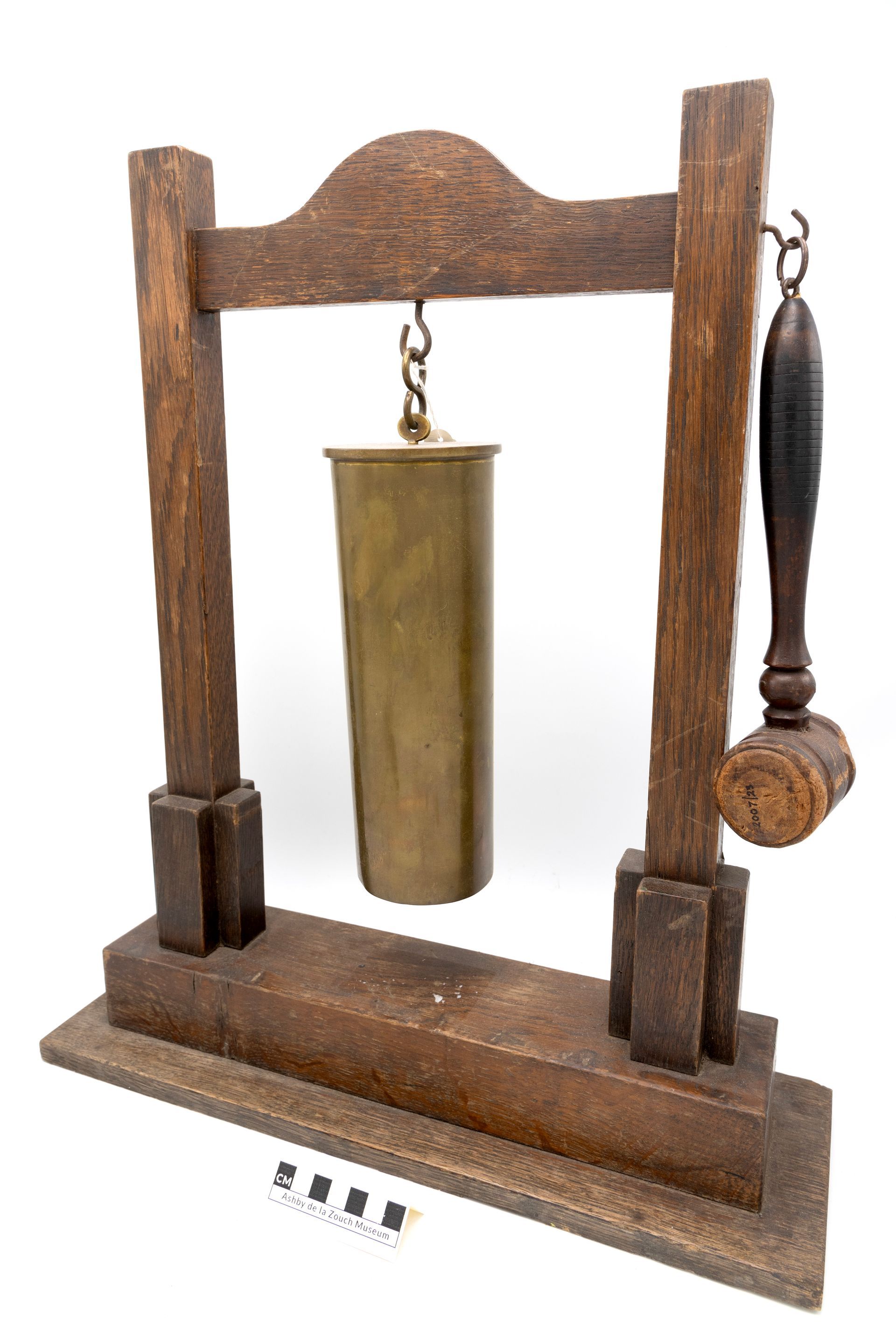 Wooden desk bell with bronze cylinder, wooden mallet hanging on the side.