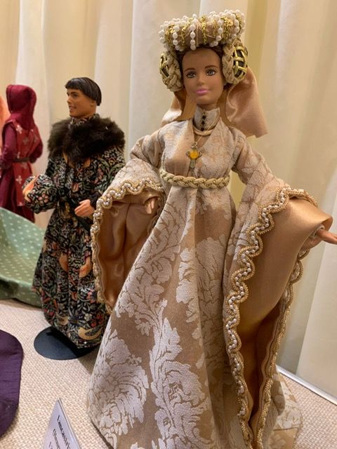 A doll is wearing a long dress and a crown.