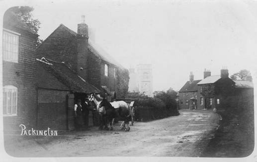 A black and white photo of a horse drawn carriage in front of a building.