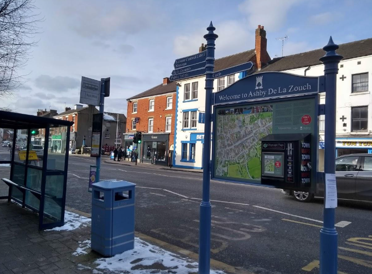 A bus stop with a map on the side of the road