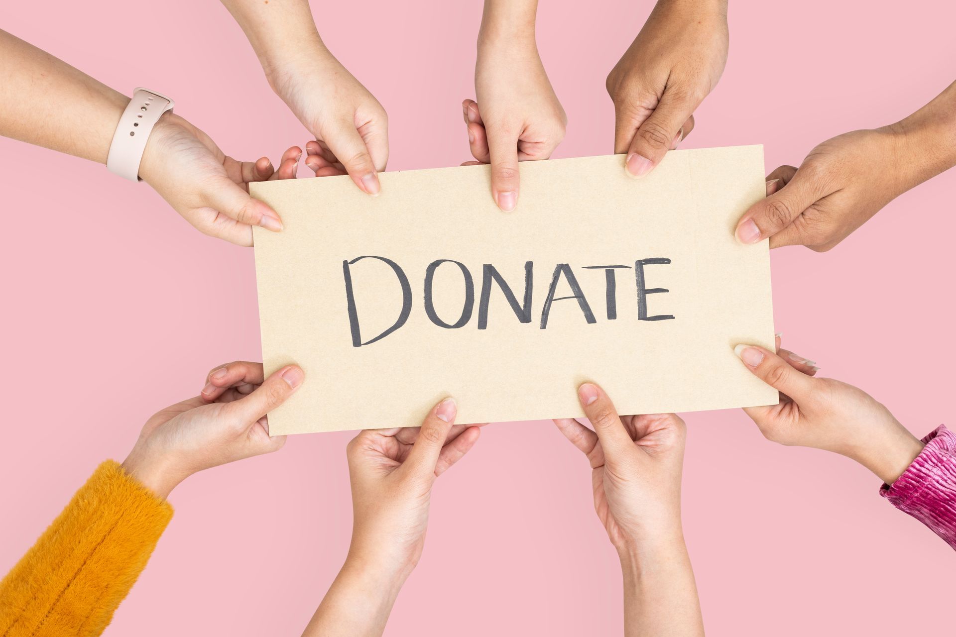 A group of people are holding a sign that says `` donate ''.