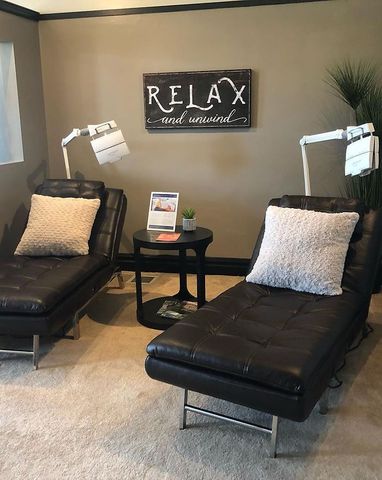 A room with two lounge chairs and a sign that says relax next to them.