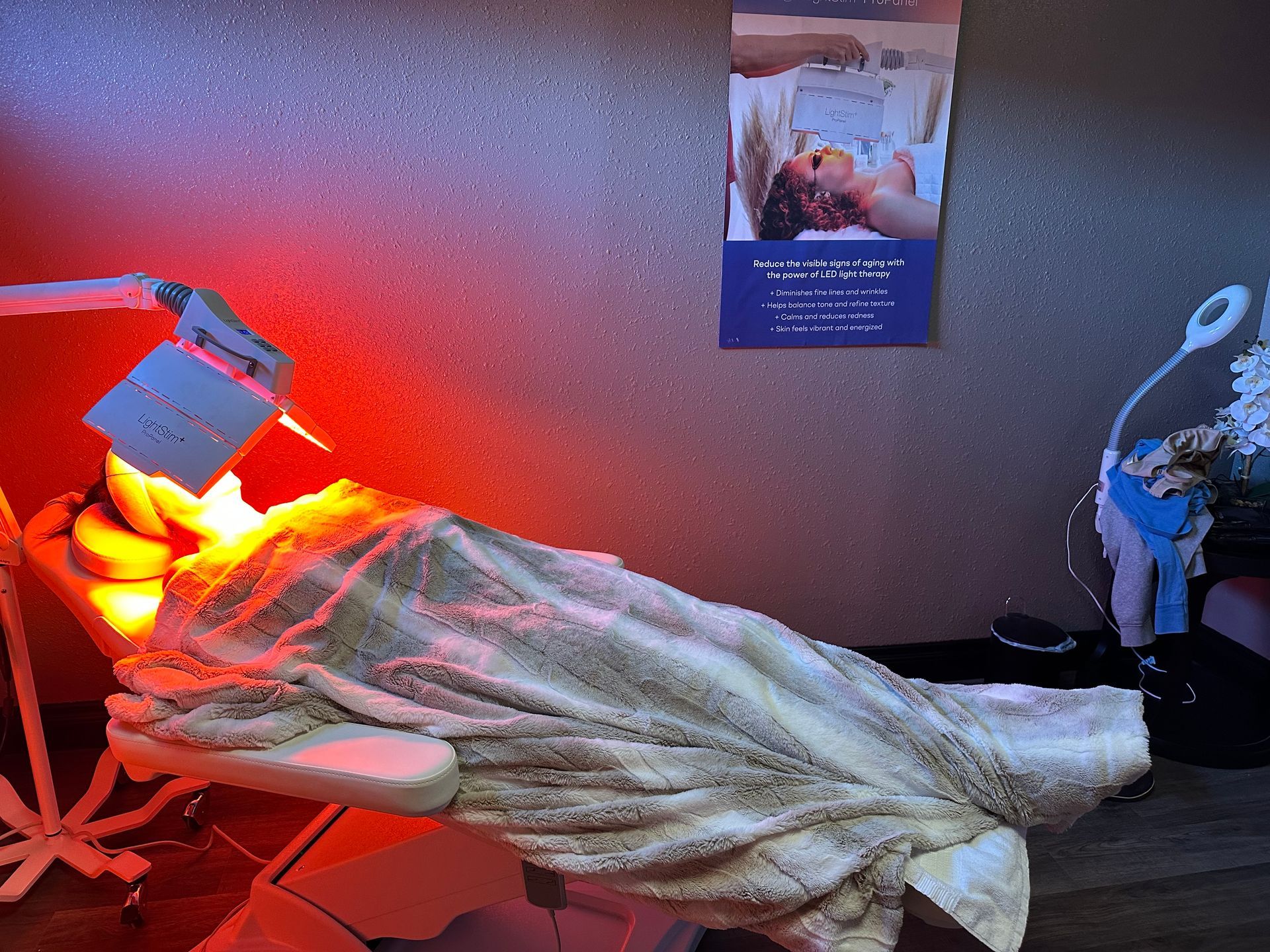 A woman is laying in a chair under a red light.