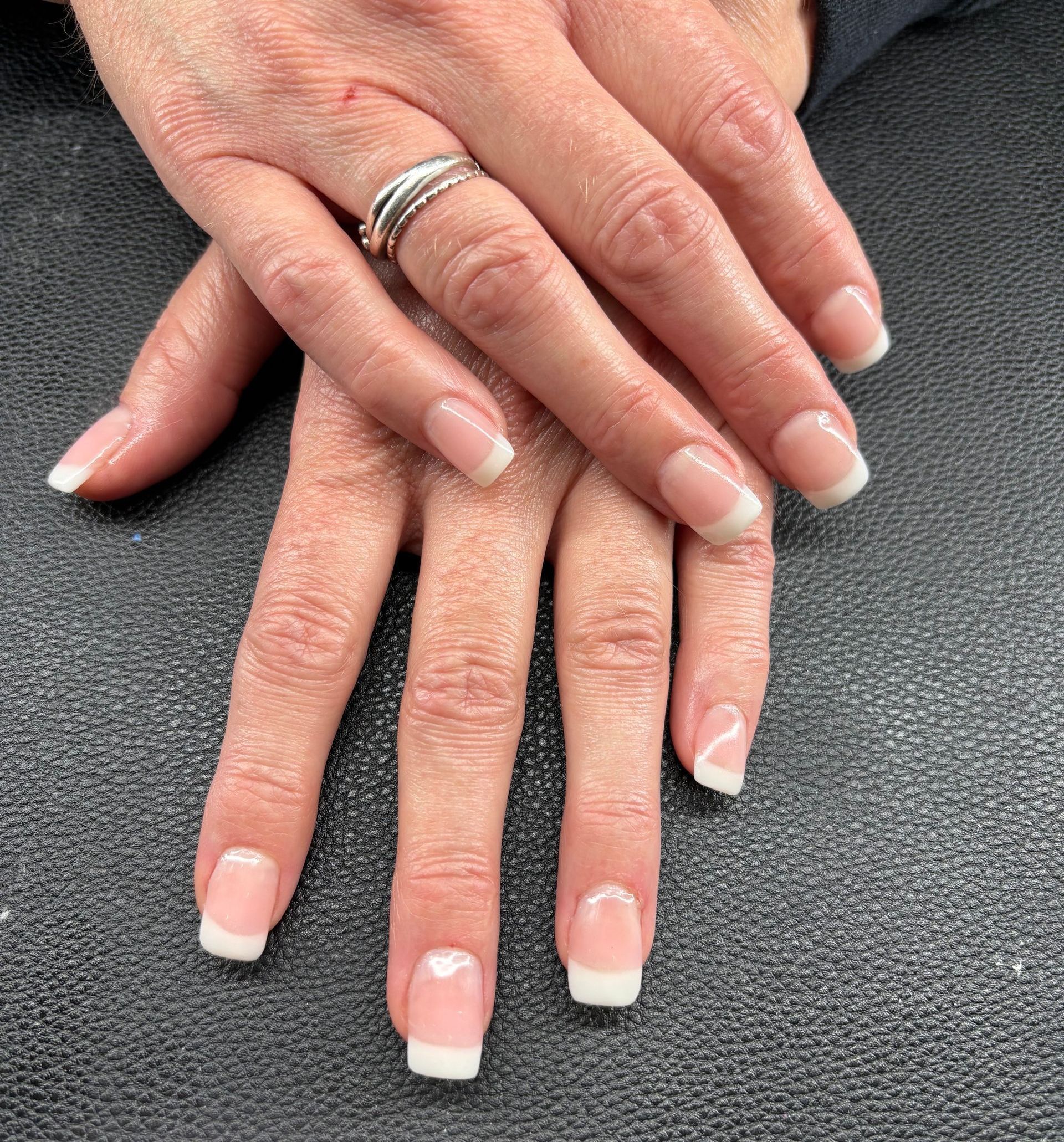 A close up of a woman 's nails with a ring on her finger.
