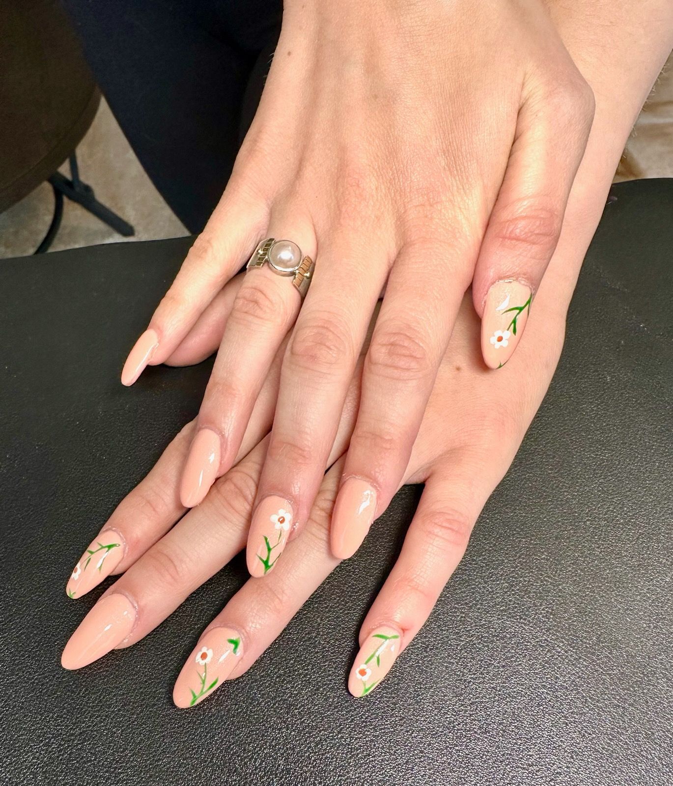 A woman 's hands with long nails and a ring on her finger