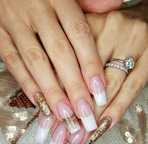 A woman 's hands with long nails and a ring on her finger.