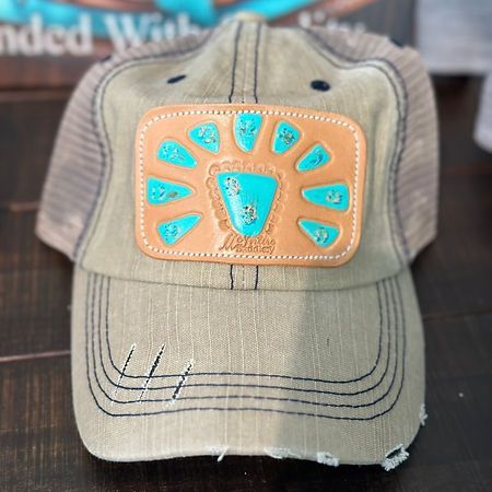 A baseball cap with a turquoise patch on it