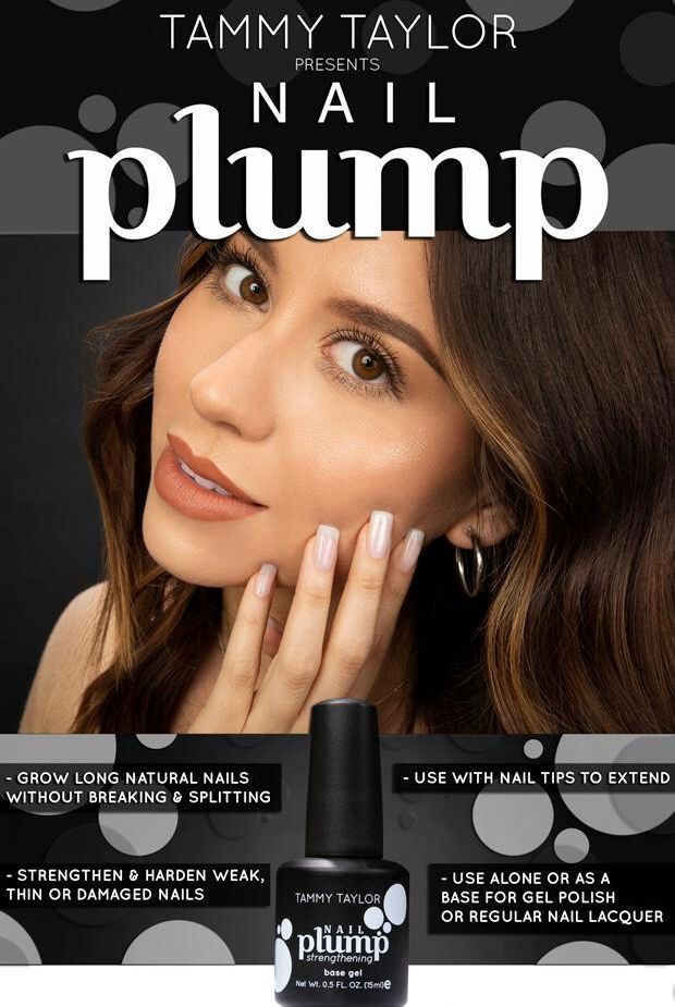 A woman is holding a bottle of nail polish in front of her face.