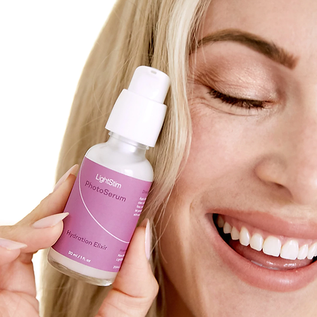 A woman is smiling while holding a bottle of lotion