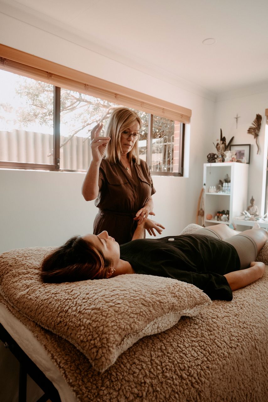 Linda Allen with a client on a massage table in clinic