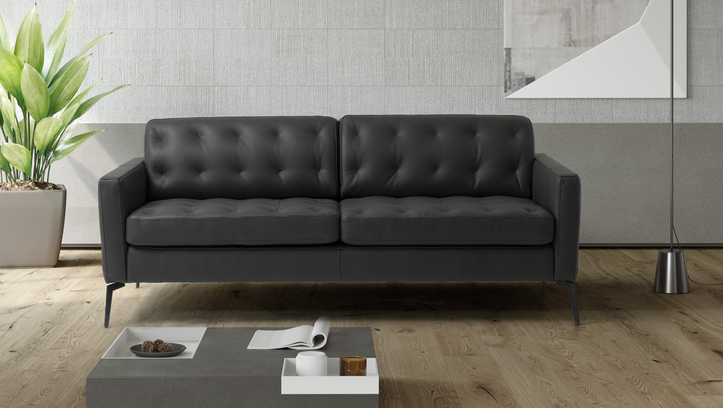 Ein schwarzes Ledersofa ist im Wohnzimmer neben einem Couchtisch positioniert.