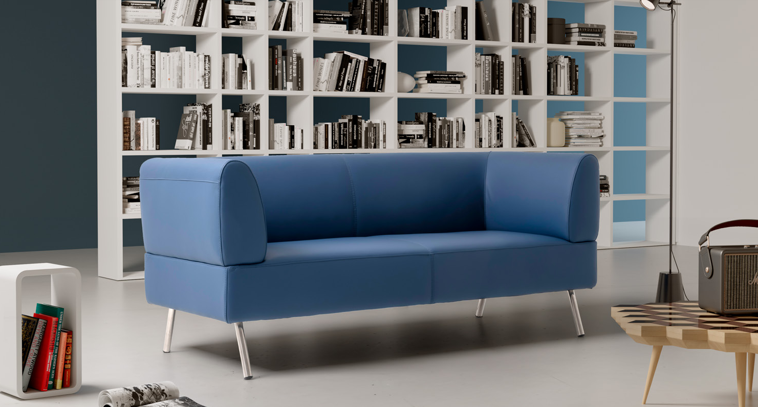 Ein blauer Sofa steht vor einem Bücherregal.
