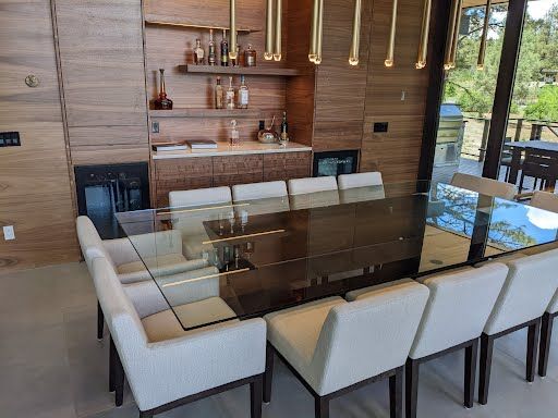 a dining room with a long glass table top crafted by Sun Glass.