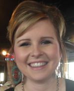 A close up of a woman wearing earrings and smiling.