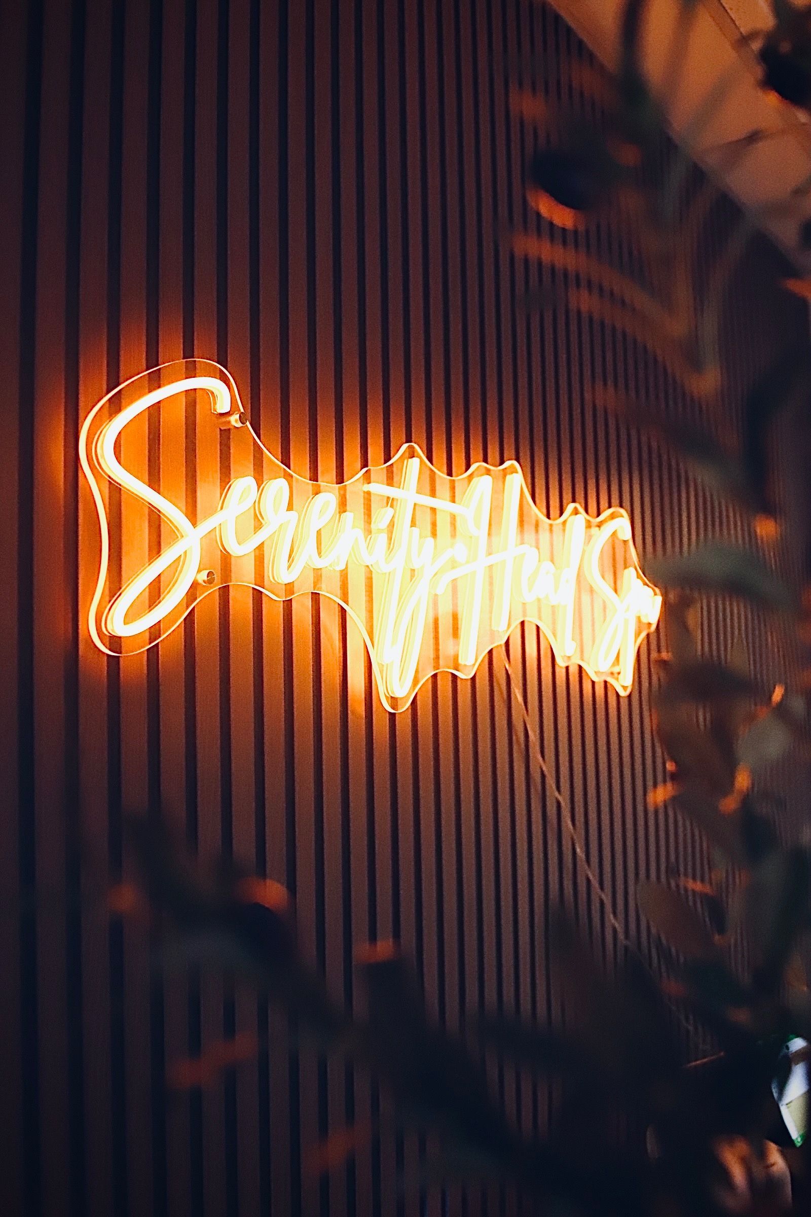Person receiving a facial massage, hands gently pressing on face. Black and white, indoors.