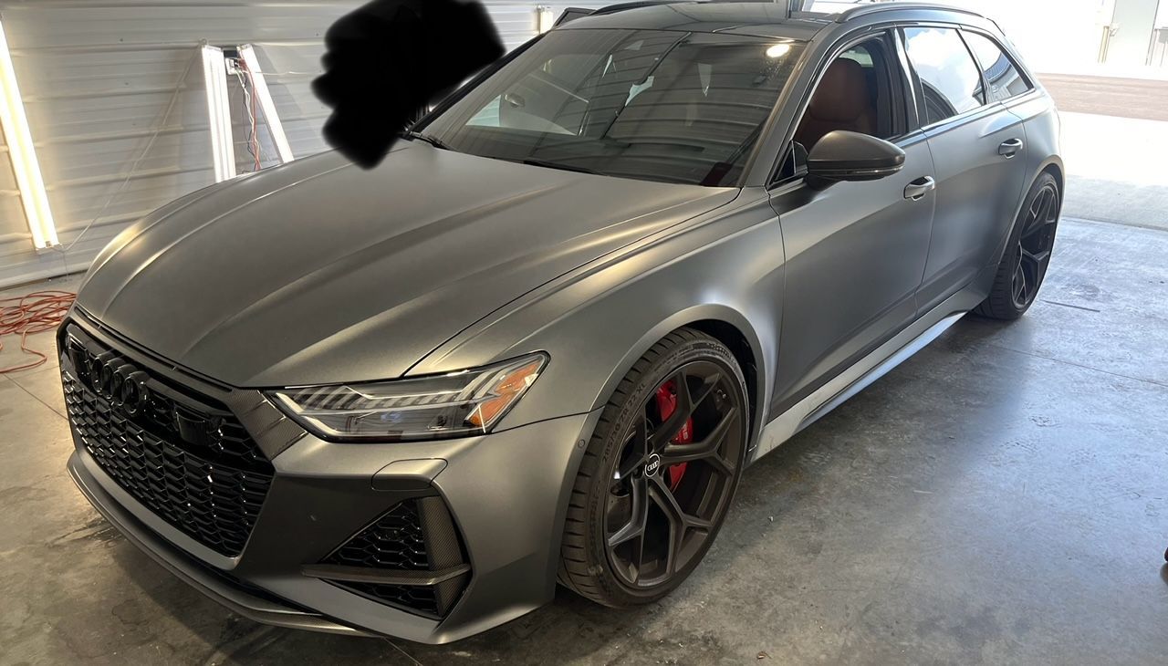 A red sports car is parked in front of a building.