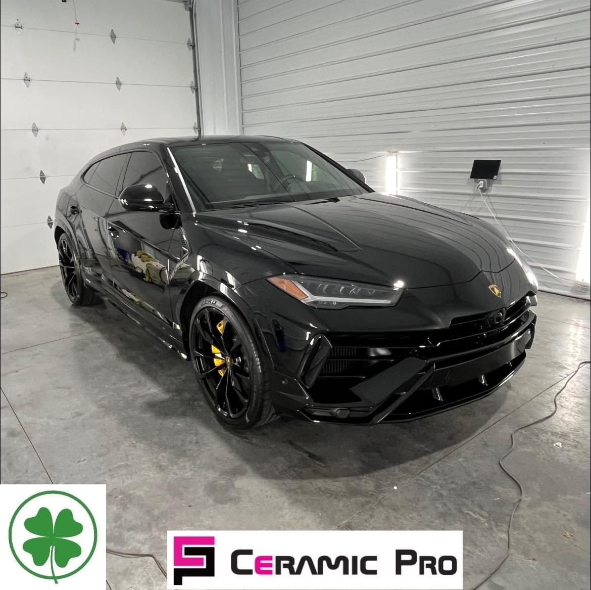 A black lamborghini urus is parked in a garage.